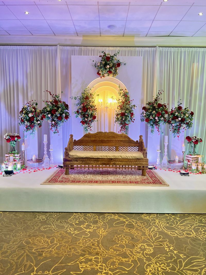 Carved bench dressed with red roses for a Nikah